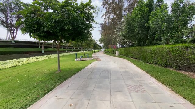Landscaped parkway alongside Dubai Creek, offering lush greenery and scenic urban waterfront views in Deira.