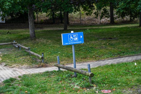 Hinweisschild f&uuml;r eine &ouml;ffentliche barrierefreie Toilette mit Rollstuhlsymbol. Zugang f&uuml;r Menschen mit Behinderung per Euroschl&uuml;ssel, Behinderten-WC, Handicap und &ouml;ffentliche Infrastruktur.