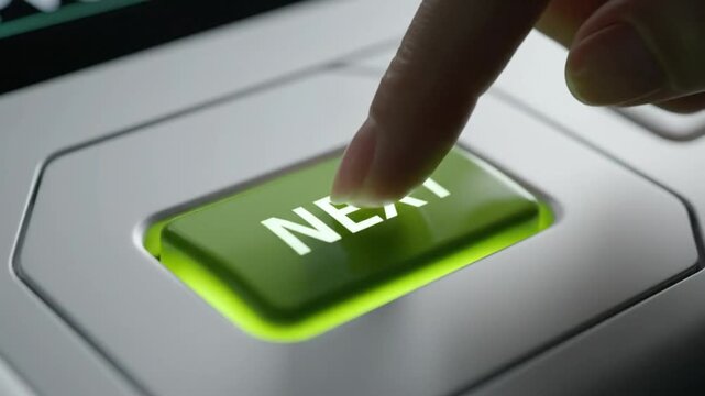 Finger pressing green illuminated next button, decision making or progression concept in close-up