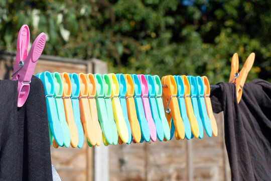 Clothes pegs and laundry garments hanging on a single long washing line being held up by pegs, tradition drying method