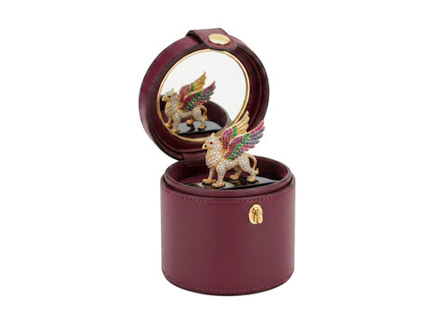 Round maroon leather jewelry box with a lid mirror displaying a mythical griffin figurine