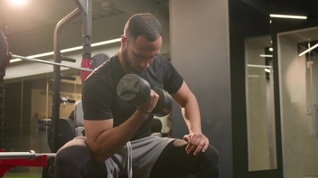 Multiethnic African American male bodybuilder lifting heavy dumbbells in gym biceps curls strong man athlete training arms muscles fitness workout in sport club healthy active lifestyle power health