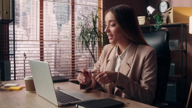 Smiling Caucasian business woman happy talking video call laptop interview greeting write at office female girl businesswoman smile talk conference computer negotiation consult chat writing notes