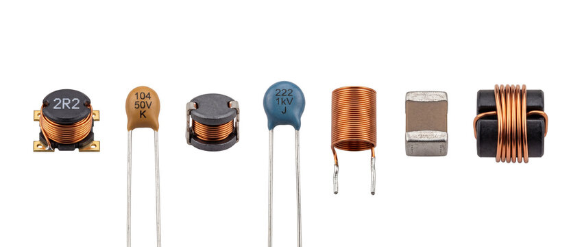 Electronic components inductors ceramic capacitors line isolated on black background for circuit board hardware design, electrical engineering, microelectronics, passive radio parts studio shot