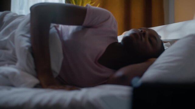 African American woman unable sleeping lying in bed at night suffering insomnia discomfort tired female girl having nightmare struggling indoors dark bedroom dreaming alarm clock health sleep problem