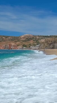 Rocks on Paleochori beach and waves of Aegean sea, Milos island, Cyclades, Greece. Tracking shot