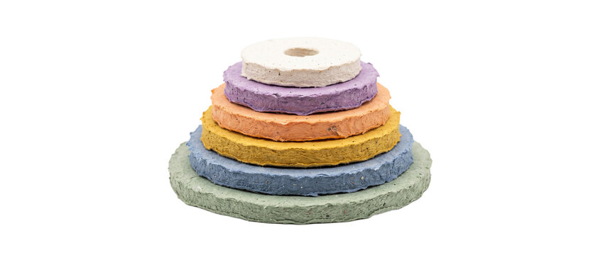 Handmade recycled paper stack colorful round discs arranged in pyramid structure isolated on black background for eco friendly sustainability, creative art, craft material and zero waste design.