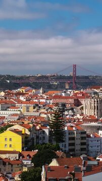 Time-lapse of Lisbon famous view from Miradouro dos Barros tourist viewpoint over Alfama old city district, 25th of April Bridge and Christ the King statue. Lisbon, Portugal. Zoom out effect and camer