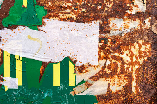 Rusty Metal with Torn Sticker Texture. Heavily corroded metal surface covered with torn paper, peeling stickers, remnants of paint. Layered rus, industrial distressed abstract background, copy space