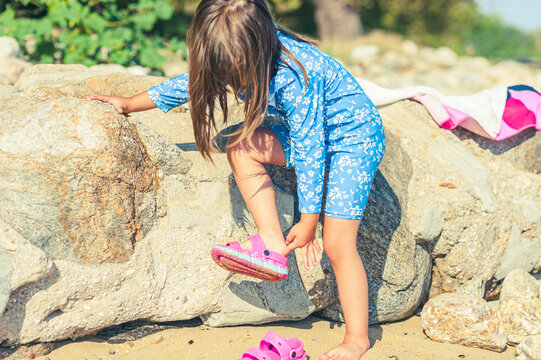 Little Girl Learning Independence by Putting on Her Own Beach Sandal
