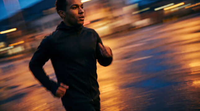 Confident female runner gazing at camera with windswept hair at sunset