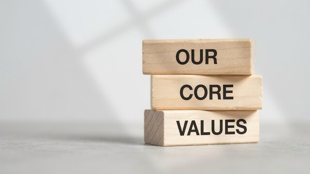 Wooden blocks stacked with the words our core values written on them in a minimalist office setting. Business ethics concept for corporate culture and company mission presentations.