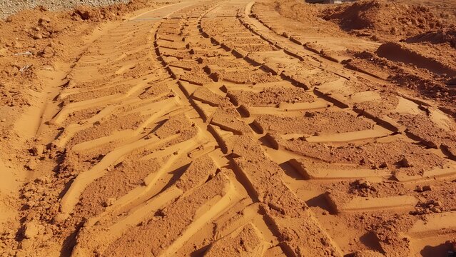 Heavy Machinery Tracks in Red Clay Soil, Construction Site Terrain, Excavation Path, Texture and Pattern Detail.