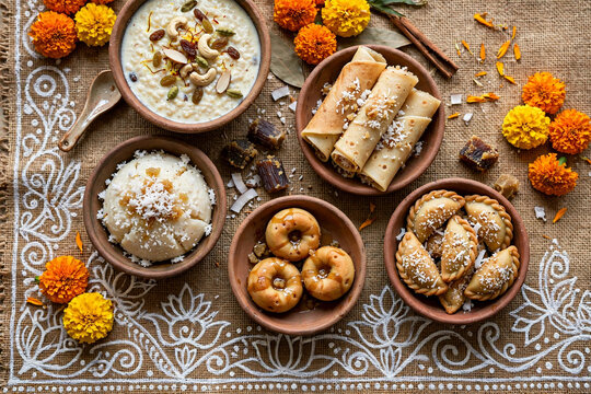 Traditional Bengali festive sweets pitha payesh patishapta puli pitha for Durga Puja and Poush Sankranti celebration on earthen bowls with alpona