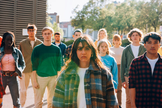 Young woman leads a crowd of protesters walking through the city