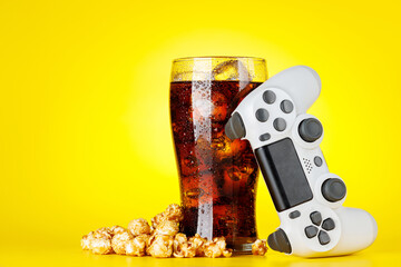 Popcorn, cola and gamepad on yellow background © Evgeny Karandaev