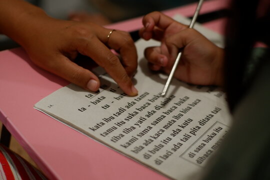 Close Up of Parent Assisting Young Daughter with School Assignment