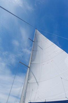 White sail against blue sky on sailing yacht