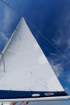 White sail against blue sky on sailing yacht