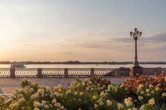 Beautiful riverside promenade with flowers at sunset