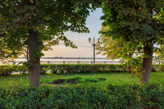 Green riverside park with trees and landscaped garden