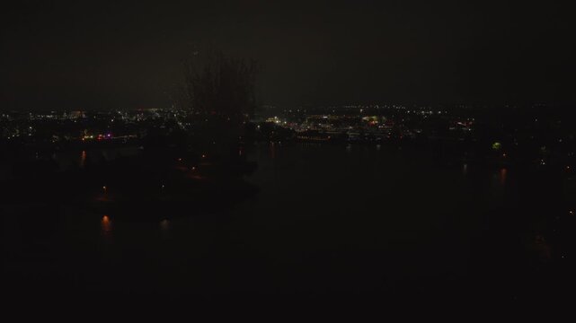High-angle aerial drone view of colorful Independence Day fireworks exploding over Big Bear Lake at Century Park in Vernon Hills, Illinois at night.