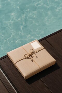 Gift Box Placed Near a Pool in a Sunny Outdoor Location During the Day