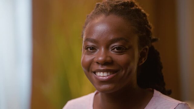 Beautiful smiling African American business woman looking at camera in bedroom at night ethnic girl preparing to sleep at home happy female businesswoman homeowner relaxing bedtime evening rest indoor