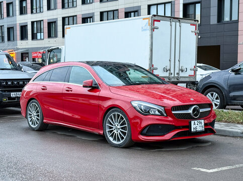 Red Mercedes-Benz CLA Shooting Brake X117 premium compact station wagon car parked outdoors. German FWD automobile vehicle based on MFA platform architecture with a turbo petrol inline-four engine.