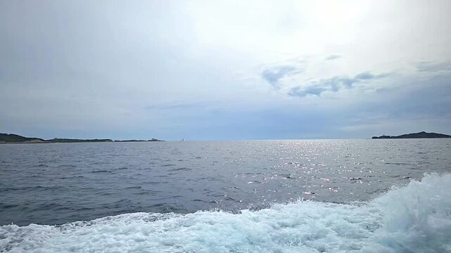 Boat trip towards Ile de Porquerolles, Port-Cros National Park, Hyeres, France, Europe. Boat wake splashing on the Mediterranean sea while sailing towards Porquerolles Island, France, Europe.