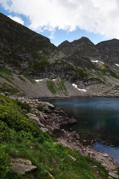 Mountain lake with rocky shore and steep cliffs