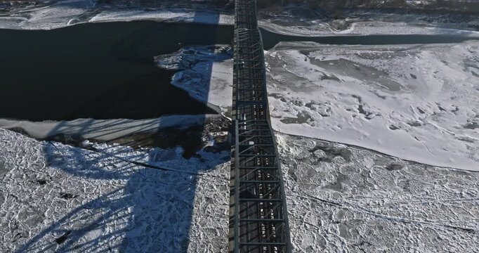 Bridge carrying traffic over river choked with frozen ice floes.