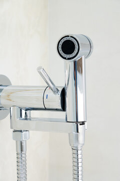 Chrome Bidet Sprayer And Faucet In Bathroom