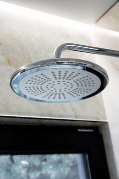 Modern chrome shower head mounted on tiled wall