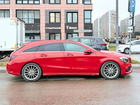 Red Mercedes-Benz CLA Shooting Brake X117 premium compact station wagon car parked outdoors. German FWD automobile vehicle based on MFA platform architecture with a turbo petrol inline-four engine.
