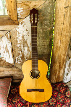 Cozy chill out zone with acoustic guitar, cushion, and rustic wooden wall