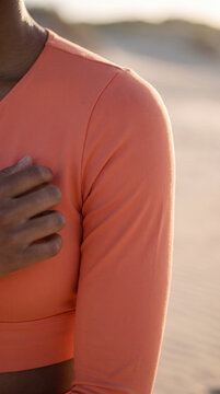 Close detail of a hand resting gently on a shoulder in warm sunset light