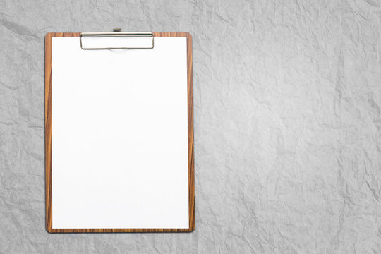 Blank white report paper on wooden clipboard on winkle paper texture background, office item, business concept