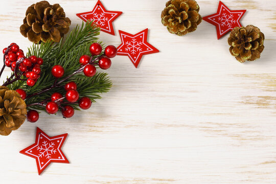 Christmas decorations (cones, wooden stars and twigs of Cristmas tree) on white painted wood