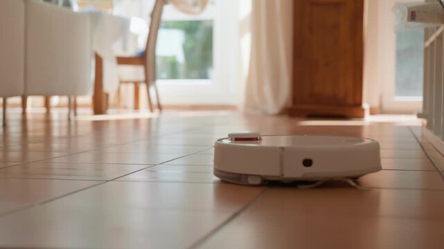 Robot vacuum vacuums and mops the floor brown tile low angle view