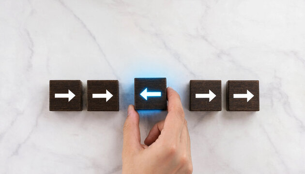 A person turning a wooden block with a glowing left arrow against the crowd
