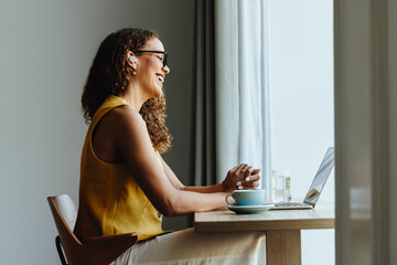 Happy african woman enjoys a video call with a client from her home office