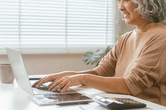 senior couple and documents with laptop for finance, budget planning or retirement annuity on sofa. Elderly man, woman or house with smile, computer or paperwork for pension fund or insurance