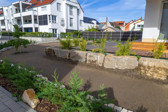 Garten- und Landschaftsbau: Gestaltung eines hochwertigen Ziergartens mit Natursteinbl&ouml;cken und immergr&uuml;nen jungen Pflanzen