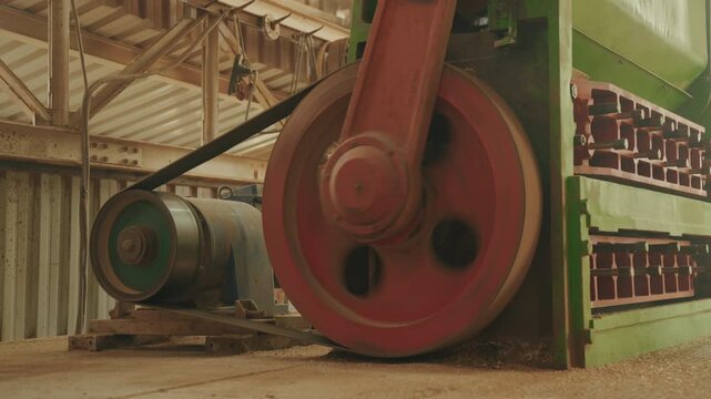 Heavy industrial vibrating sifter machine powered by electric motor and rotating pulley belt flywheel in factory   