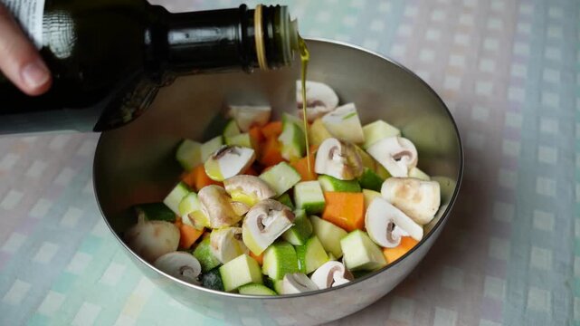 Pouring Cooking Oil Over Fresh Vegetables. Cooking oil is poured over a colorful mixture of fresh vegetables before they are saut&eacute;ed.