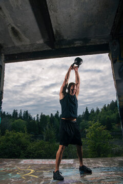White man performing kettlebell exercise outdoors