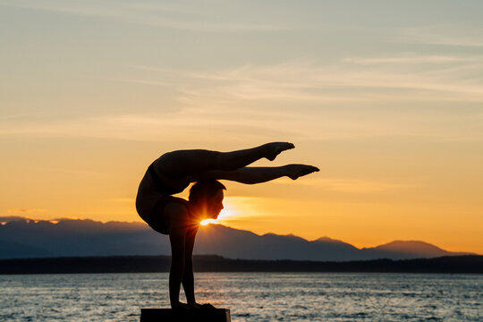 White woman doing acrobatic handstand pose