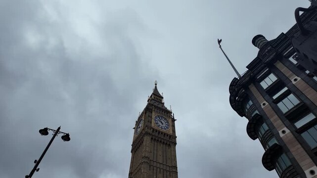 4K UHD panning shot rising past Big Ben clock tower with moody overcast sky