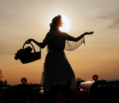 Silhouette of white woman holding flower basket